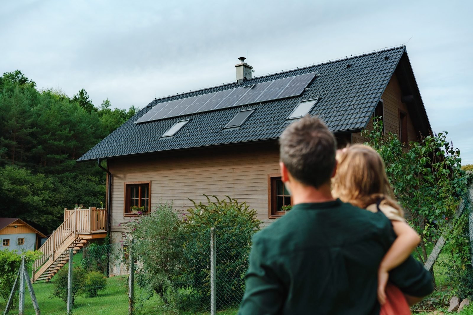 Famille devant leur maison équipée de panneaux solaires